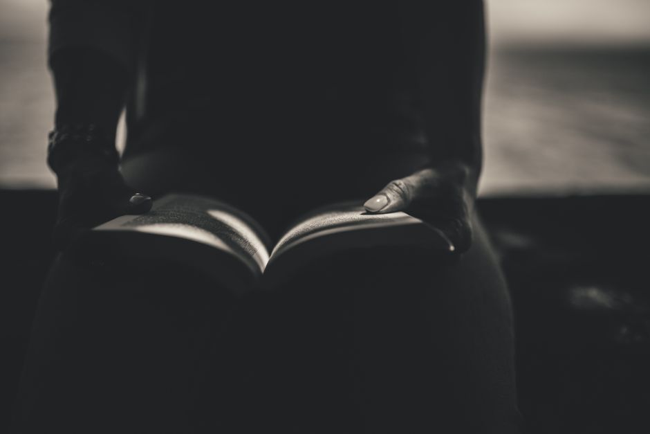 Woman enjoying relaxation by reading a book on a cozy couch indoors.