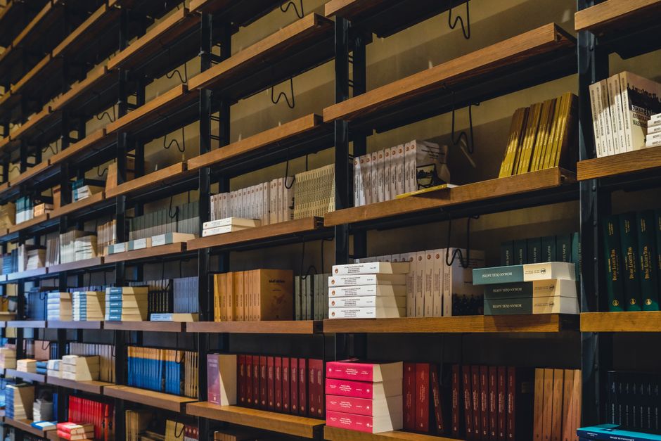 A cozy indoor bookstore with stacked bookshelves filled with novels and literature.