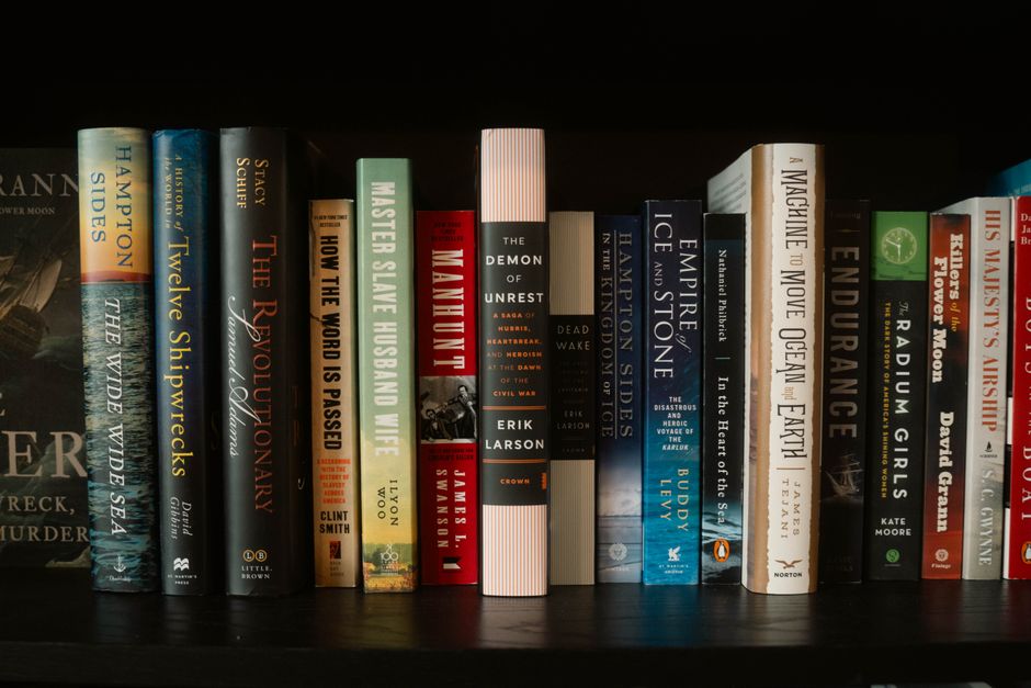 A cozy indoor bookstore with stacked bookshelves filled with novels and literature.