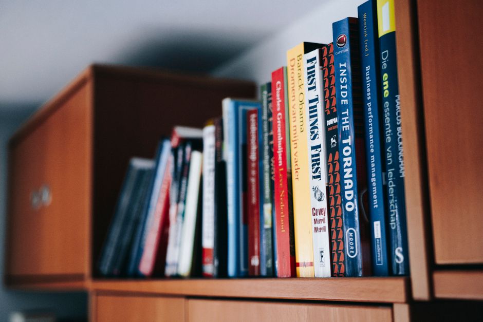 A close-up view of a stack of vintage and modern books with a focus on open pages, offering a sense of knowledge and history.