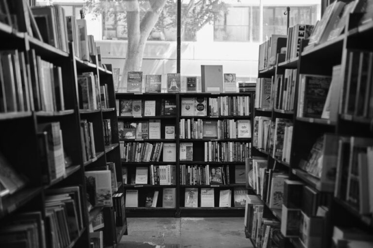 Black and white photograph of a welcoming bookstore interior lined with bookshelves.